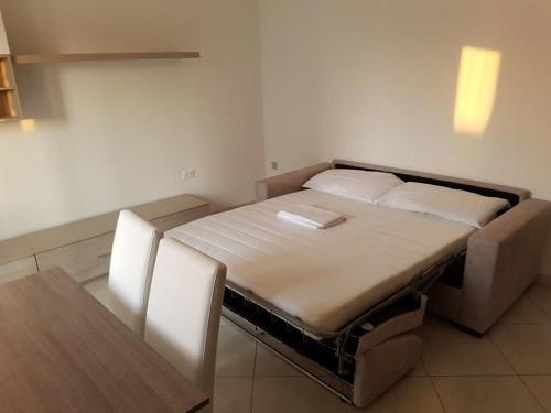 a bed in a room with two chairs and a table at Sottomarina Beach Life in Sottomarina
