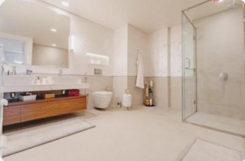 y baño con ducha, lavabo y aseo. en PENTHOUSE BURJ AL ARAB FRONT en Dubái
