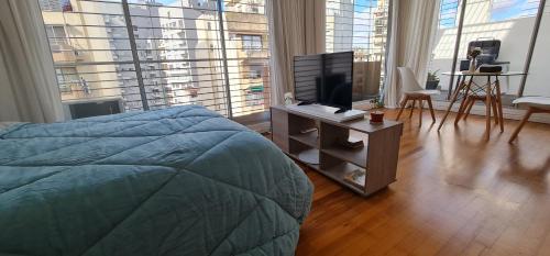een slaapkamer met een bed en een televisie op een tafel bij Cozy studio in Recoleta in Buenos Aires