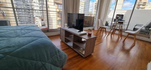 een slaapkamer met een bed en een televisie op een dressoir bij Cozy studio in Recoleta in Buenos Aires
