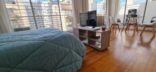 een slaapkamer met een bed en een televisie op een tafel bij Cozy studio in Recoleta in Buenos Aires