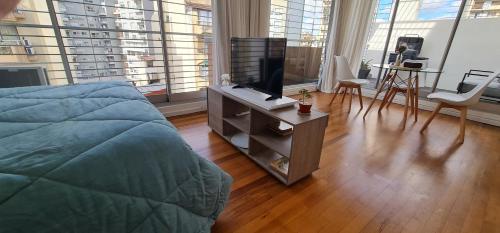 een slaapkamer met een bed en een tv op een dressoir bij Cozy studio in Recoleta in Buenos Aires