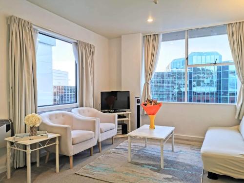a living room with a couch and chairs and a tv at Wellington Central, 2bedroom Suite in Wellington