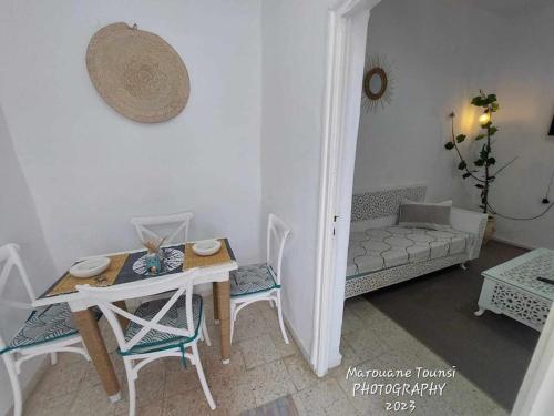 salon ze stołem, krzesłami i kanapą w obiekcie Studio de charme w mieście Houmt Souk