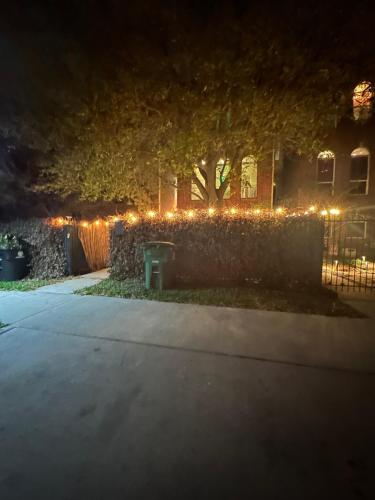 uma cerca com luzes de Natal em frente a uma casa em The Hanger em Houston
