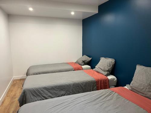 Zimmer mit 2 Betten und blauer Wand in der Unterkunft Appartement cosy parking idéal JO 2024 in Le Bourget