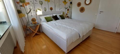 a bedroom with a bed and a wall with flowers at Helle Ferienwohnung mit Garten und Terrasse, direkt am Waldrand gelegen in Herzogenrath
