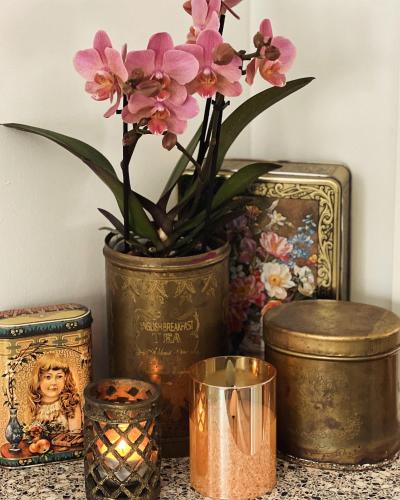 a table with a vase with flowers and candles at Charmig liten stuga i Södertälje/ Kungsdalen in Södertälje