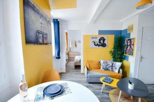 - un salon avec des murs jaunes et un canapé dans l'établissement Le Banksy, à La Seyne-sur-Mer