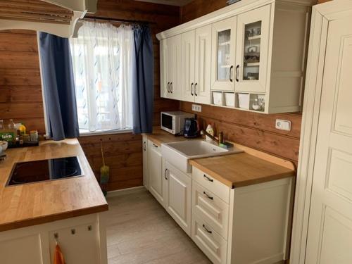 a kitchen with white cabinets and a sink at Chata ve Zdobnici in Zdobnice