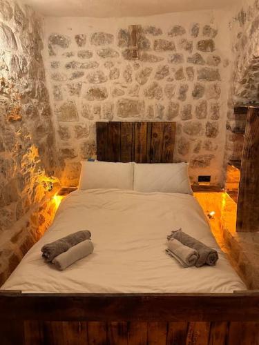 Una cama en una habitación con dos toallas. en Tarihi Mardin evi Hobbit ev en Mardin