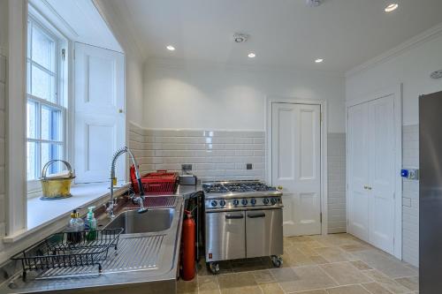 a kitchen with a sink and a stove at House of the Northern Gate - a luxury baronial house that sleeps 18 guests in 9 bedrooms in Thurso