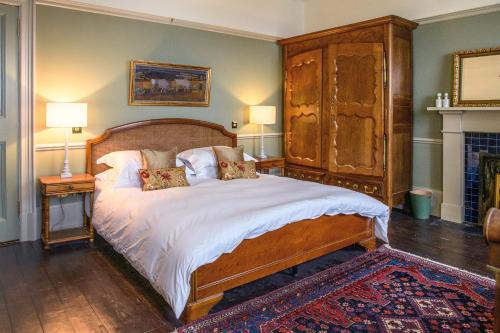a bedroom with a large bed with a wooden headboard at House of the Northern Gate - a luxury baronial house that sleeps 18 guests in 9 bedrooms in Thurso