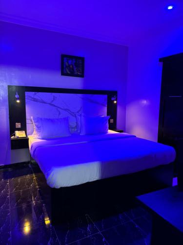 a purple bedroom with a large bed with a purple ceiling at Posh Hotel and Suites Ikeja in Ikeja