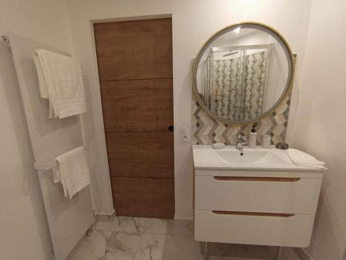 une salle de bain avec un lavabo blanc et un miroir dans l'établissement Résidence bord de mer, Cannes Midi, Accès direct à la plage, à Cannes