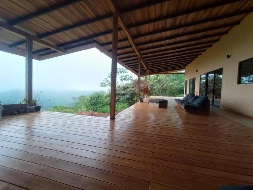 a wooden deck with a view of the mountains at VillaarcoirisCR in San Ramón