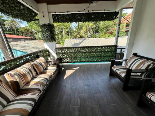a balcony with couches and a swimming pool at Beautiful View House in Tortuguero