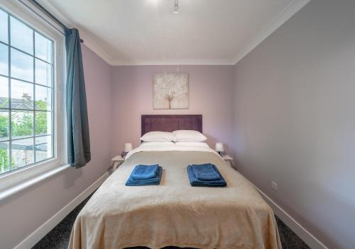 a bedroom with a bed with two blue towels on it at One bedroom Flat Free Parking in London