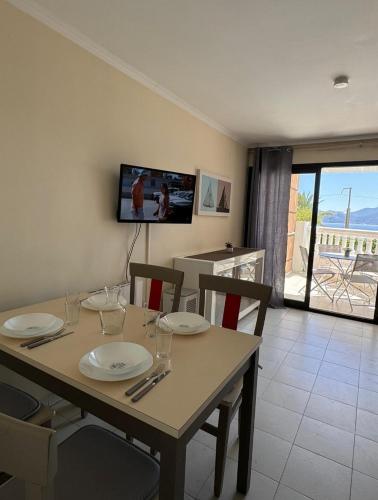 une salle à manger avec une table avec des chaises et une télévision dans l'établissement Cannes appartement vue mer , piscine, à Cannes