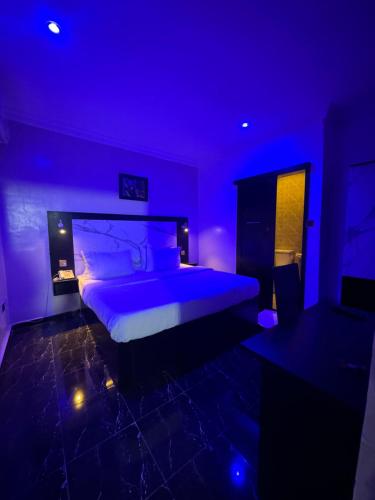 Fioletowa sypialnia z dużym łóżkiem w pokoju w obiekcie Posh Hotel and Suites Ikeja w mieście Ikeja