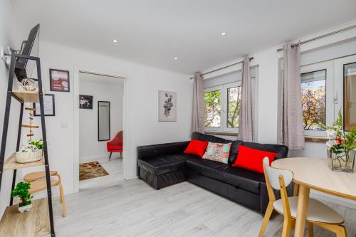 a living room with a black couch and a table at Mia guest House R/C in Setúbal