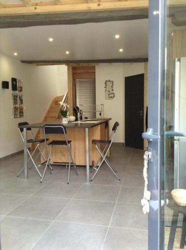 a kitchen with a table and chairs in a room at Les Co Gîte in Vigny