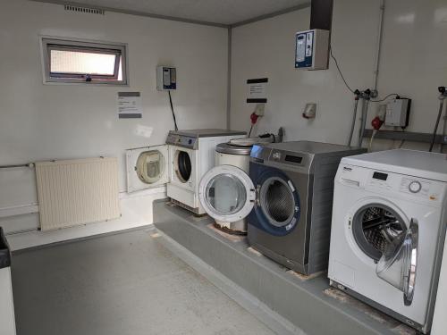エークトにあるStacaravan Il Piccolo Nido in Bosrijke Omgeving, Rust & Natuur in Drentheの洗濯機3台、洗濯機、乾燥機が備わるランドリールーム