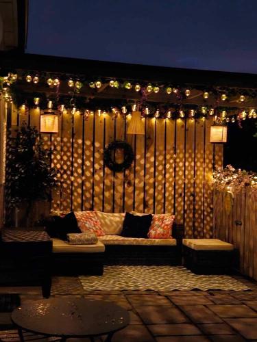 a patio with a couch and a bunch of lights at Croí Beag Luxury Studio Omeath in Dundalk