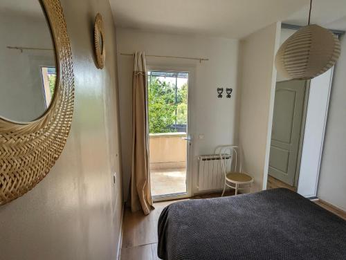 - une chambre avec un lit, un miroir et une porte dans l'établissement Gîte Le Bosquet - Au cœur du Luberon, à Apt