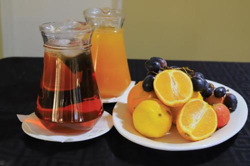 a plate of fruit and a jar of honey and juice at Etang Guesthouse in Nata