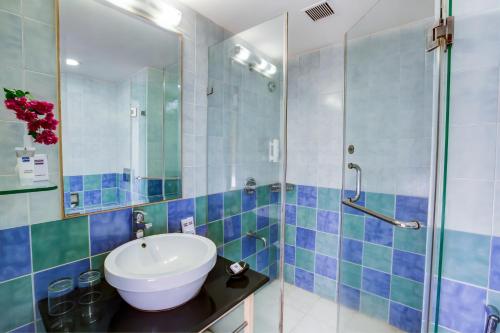 a bathroom with a sink and a shower at Radha Hometel in Bengaluru
