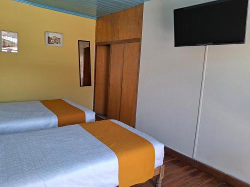Ένα ή περισσότερα κρεβάτια σε δωμάτιο στο Hostal Lluvia de Oro