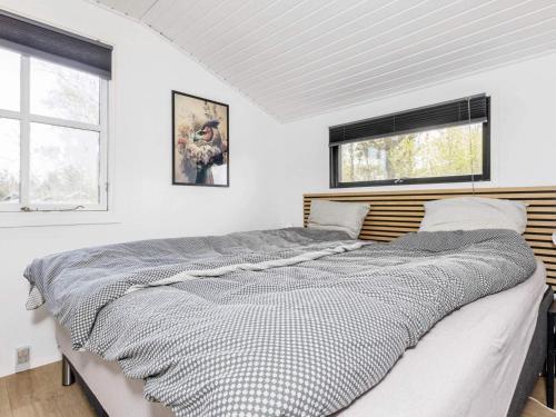 een groot bed in een witte kamer met 2 ramen bij Holiday home Løgstør IX in Løgsted
