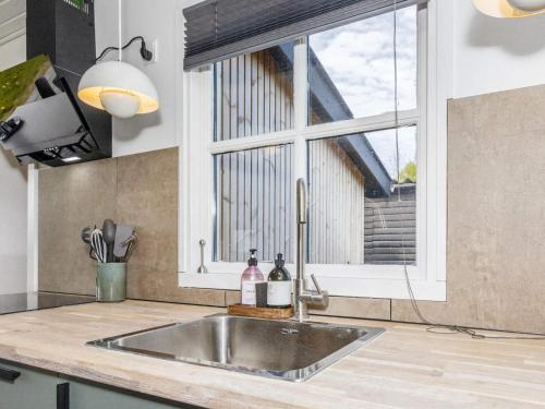 een wastafel in een keuken met een raam bij Holiday home Løgstør IX in Løgsted