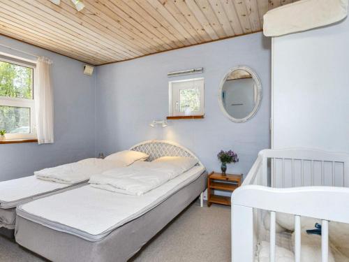 1 dormitorio con 2 camas y espejo en Holiday home Højslev IV, en Højslev