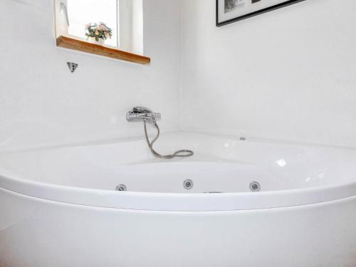 bañera blanca con grifo en el baño en Holiday home Højslev IV, en Højslev