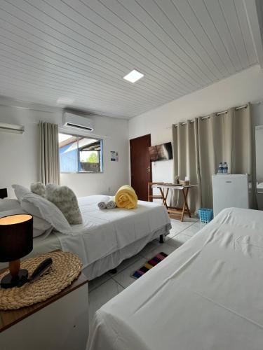 a bedroom with two beds and a kitchen with a table at Flor do Mar - bed and breakfast in Santa Cruz