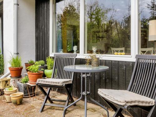 a patio with two chairs and a table and a window at 6 person holiday home in Farsø-By Traum in Farsø