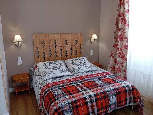 a bedroom with a bed with a plaid blanket at Domaine de la Moselle in Saint-Maurice-sur-Moselle