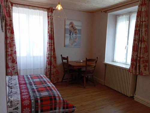 1 dormitorio con mesa, cama y ventana en Domaine de la Moselle, en Saint-Maurice-sur-Moselle