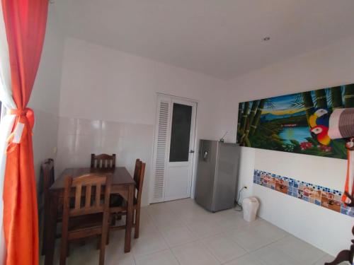 a kitchen with a table and a refrigerator at Finca Hotel Villa Ilusión in Pereira