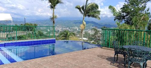 a balcony with a pool and a table and chairs at Finca Hotel Villa Ilusión in Pereira