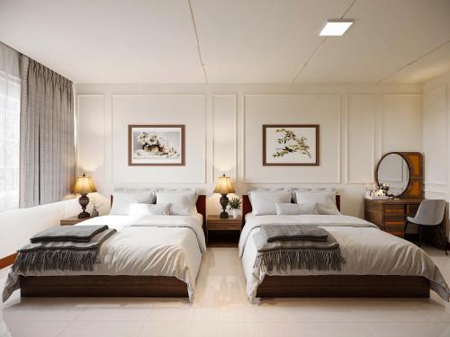 a bedroom with two beds and a mirror at Baglioni Signature in Ho Chi Minh City