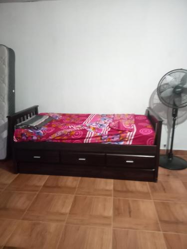 a bed in a room with a fan and a floor at Amplio monoambiente in Paraná