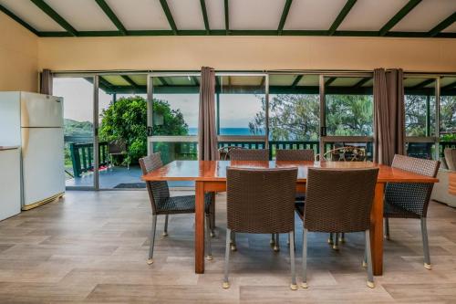 a kitchen and dining room with a table and chairs at Endeavour - Rustic Two-Bedroom Home With Stunning Ocean & 1770 Headland Views in Seventeen Seventy