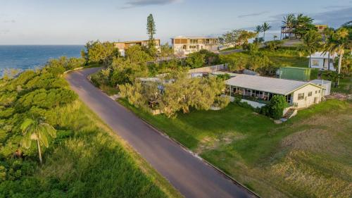 an aerial view of a house and a road at Endeavour - Rustic Two-Bedroom Home With Stunning Ocean & 1770 Headland Views in Seventeen Seventy