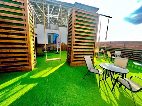 a balcony with green grass and a table and chairs at رويال جروب اربد Royal Group Hotel in Irbid
