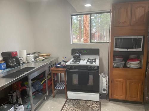 uma cozinha com um fogão, um lavatório e um micro-ondas em Cheerful 2-Bedroom Cottage Near Eagle Lake em Susanville