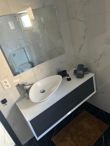 W łazience znajduje się biała umywalka i lustro. w obiekcie Havre de paix w mieście Verlaine