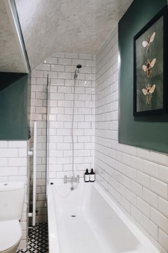 a bathroom with a white tub and a toilet at Bee Stays - Long Lane in Warrington